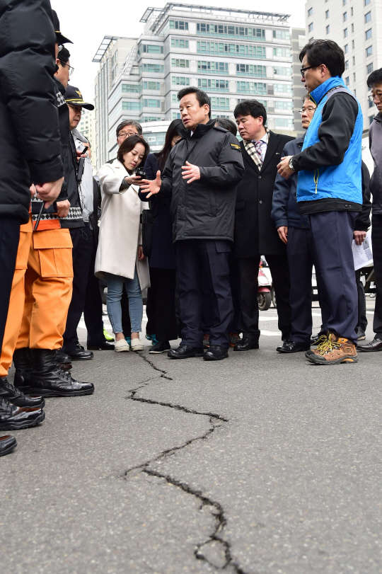 박인용 국민안전처 장관(가운데)이 2일 오전 서울 용산역 앞 광장 인근 보도 균열 현장을 방문해 서울시 관계자, 민간 전문가 등에게 상황 설명을 듣고 조속한 복구를 당부했다. 국민안전처 제공